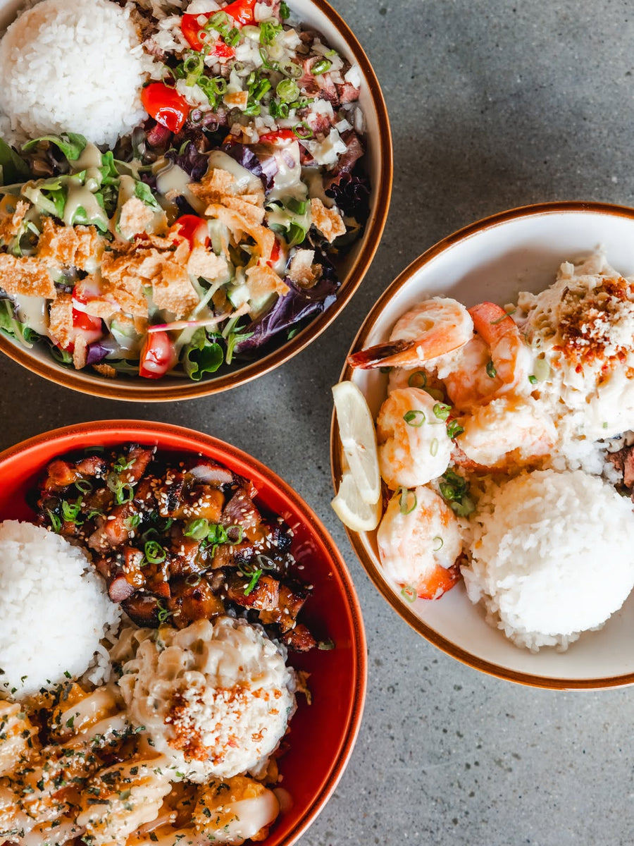 Overhead view of Hawaiian bowls with rice and toppings at Side of Aloha