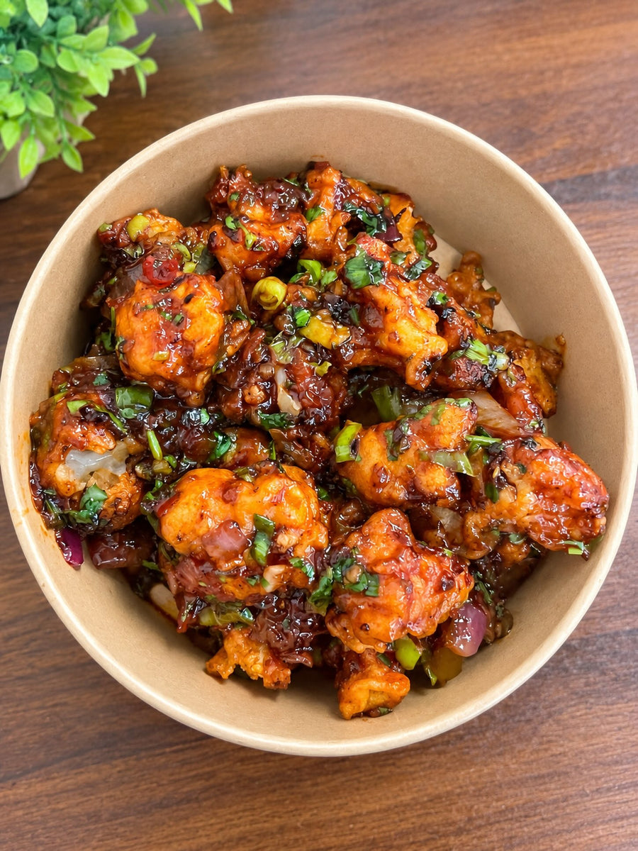 Sauce-coated vegetarian bites garnished with chopped herbs at Sri Annapoorani